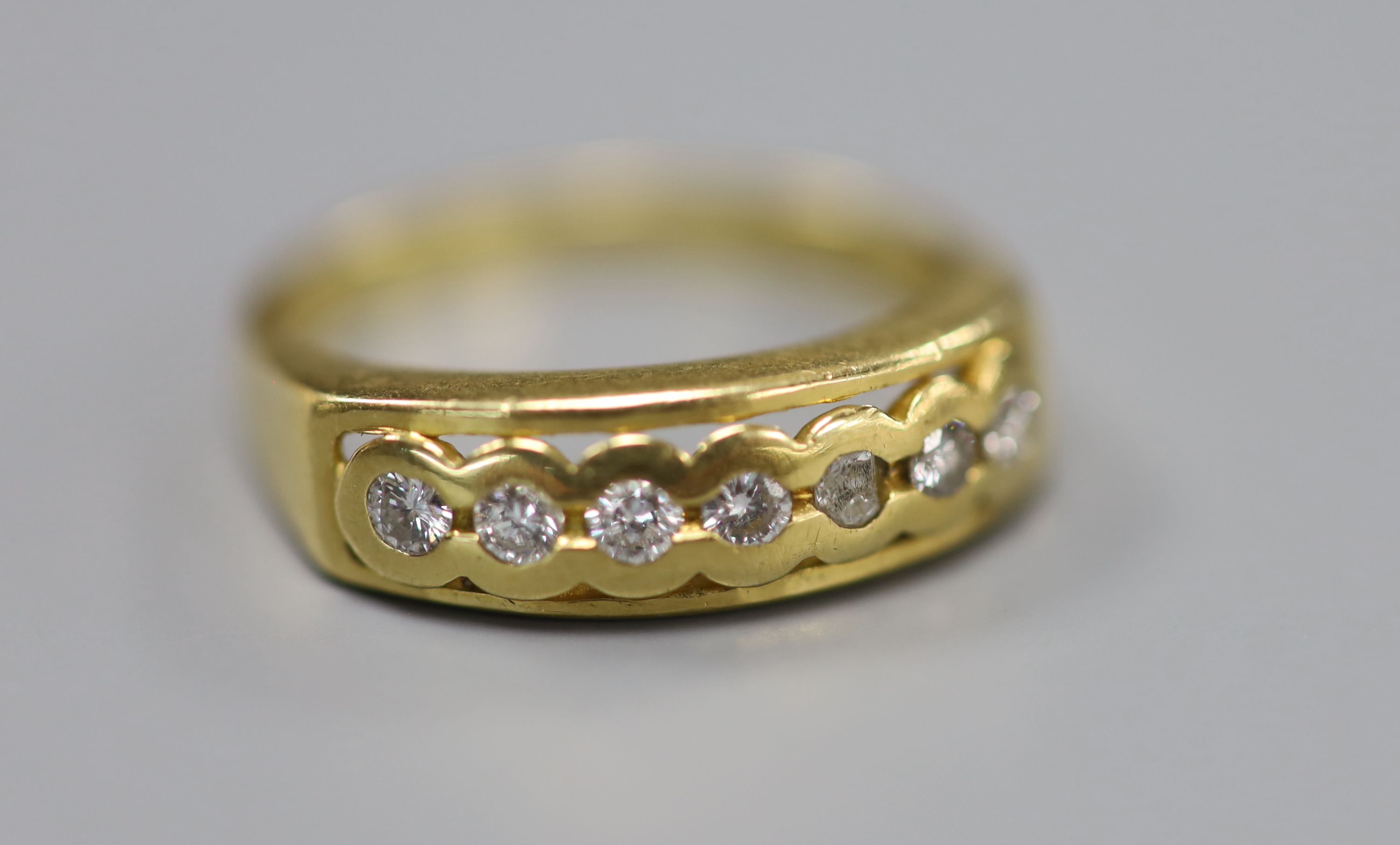 A modern 18ct gold and seven stone diamond set half eternity ring, size O, gross 4.1 grams.